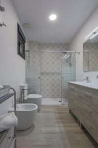 łazienka z wanną, toaletą i umywalką w obiekcie Family HOME SUITS Encantos de Sevilla w Sewilli +37 zdjęć