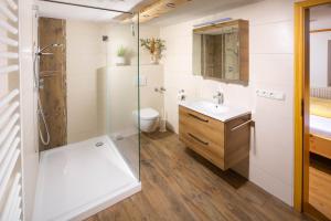 Un baño con ducha, lavabo e inodoro. en Gästehaus Pfnürlehen, en Berchtesgaden