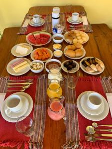 a table with plates of food and glasses of wine at Pousada Portal do Cerrado in Pirenópolis