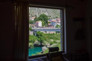 a window with a view of a river and bridge at Apartman Dva mosta in Mostar