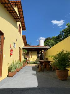 un patio de un edificio con una mesa y macetas en Pousada Portal do Cerrado en Pirenópolis