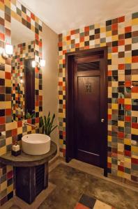 a bathroom with a sink and a wooden door at Hotel Casa Delina in Comitán