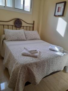 ein Schlafzimmer mit einem Bett mit zwei Handtüchern darauf in der Unterkunft Torremolinos Beach Apartment in Torremolinos
