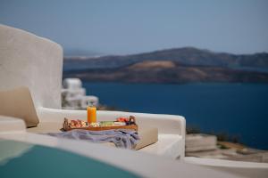 a table with a candle on top of a white chair at Akrorama private villas and suites in Akrotiri