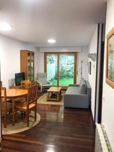 a living room with a couch and a table at Casa Buganvilla. Apartamento con jardín, a 100 metros del centro. in Comillas