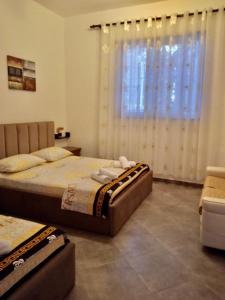 a bedroom with two beds and a window at Fati Guest House in Durrës