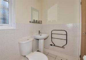 Baño blanco con aseo y lavamanos en Coram Lodge, en Lyme Regis