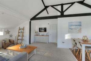 a living room with a table and a dining room at 11 The Gables in Lyme Regis