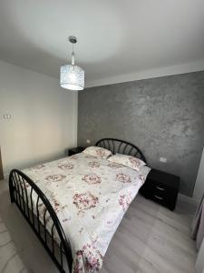a bedroom with a bed with a floral bedspread at Borșa ApartHotel 4 in Borşa