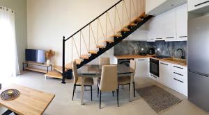 uma cozinha e sala de jantar com uma mesa e escadas em Almeta Suites em Quios