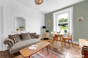 a living room with a couch and a table at Cozy with Character Cochrane Cottage at Leith Links Park in Edinburgh