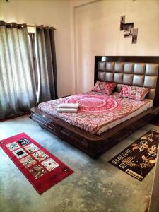 a bedroom with a bed in a room with rugs at Le Jardin . (The garden) in Almora