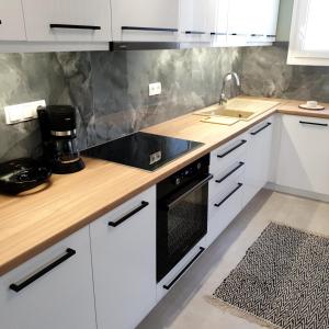 a kitchen with white cabinets and a black stove top oven at Almeta Suites in Chios