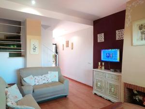 a living room with a chair and a tv at Bonito adosado playas Islantilla in Islantilla