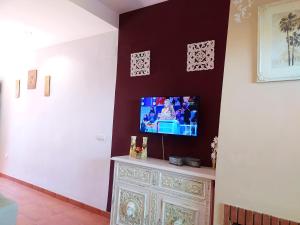 a living room with a tv on a wall at Bonito adosado playas Islantilla in Islantilla