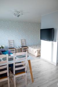 a living room with a tv and a table and chairs at Roosi apartment Haapsalu in Haapsalu