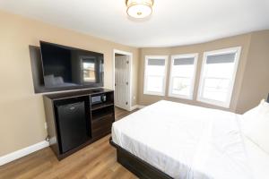 a bedroom with a bed and a flat screen tv at Seaside Sands Inn in Seaside Heights