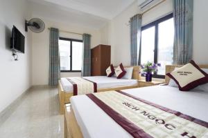 a hotel room with two beds and a television at Bích Ngọc Hotel Quan Lạn - Thứ 7 nhận 5 phòng trở lên in Làng Liễu