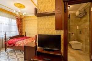 1 dormitorio con 1 cama y TV de pantalla plana en The First Ottoman Apartments, en Estambul