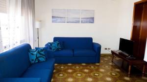 sala de estar con sofá azul y TV en Civico 177, en Avola