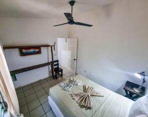 1 dormitorio con 1 cama y ventilador de techo en Escondite Pacifico, en Popoyo