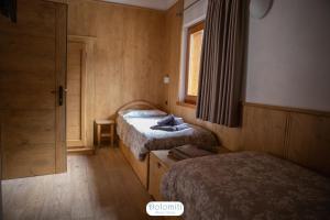Habitación pequeña con 2 camas y ventana en Dolomiti RiverSide, en Perarolo di Cadore