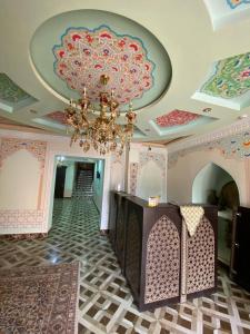a room with a ceiling with a chandelier and a hallway at Shayx Jalol in Bukhara