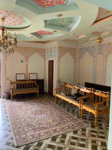 een kamer met meerdere bedden en een plafond met schilderijen bij Shayx Jalol in Bukhara