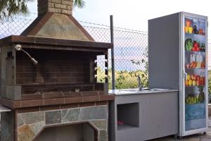 an outdoor kitchen with a brick oven and a refrigerator at Villa Hara in Nea Irakleia