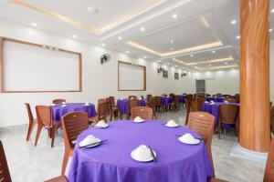 a conference room with purple tables and chairs and a screen at Bích Ngọc Hotel Quan Lạn - Thứ 7 nhận 5 phòng trở lên in Làng Liễu