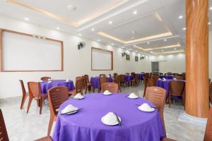 a conference room with purple tables and chairs and a screen at Bích Ngọc Hotel Quan Lạn in Làng Liễu