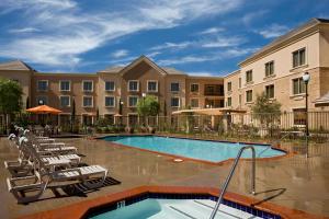 una piscina con sillas y un edificio en Ayres Hotel Chino Hills - Ontario, en Chino Hills