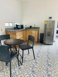 een keuken met een tafel en stoelen en een koelkast bij CASA JURADO in Medellín