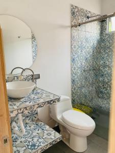 een badkamer met een wastafel, een toilet en een spiegel bij CASA JURADO in Medellín