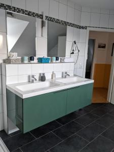 a bathroom with two sinks and a mirror at Ferienhaus Lindelburg in Schwarzenbruck
