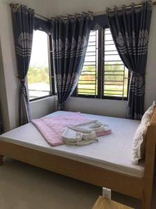 uma cama num quarto com uma janela em Song Châu Villa Quan Lạn em Quang Ninh
