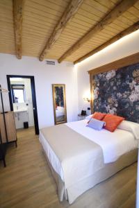 a bedroom with a large white bed in a room at Hostal Rural Santa Habitaciones Aldea del Rocío in El Rocío