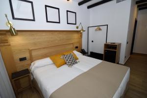 a bedroom with a white bed with two pillows on it at Hostal Rural Santa Habitaciones Aldea del Rocío in El Rocío