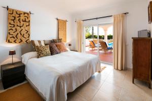 a bedroom with a bed and a sliding glass door at Golf- Villa mit fantastischer Aussicht, Pool, Jacuzzi, Sauna, Golf, Tennis... in Budens