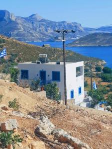 a white building on top of a hill with water at Villa Irene in Kalymnos
