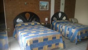 Zimmer mit 2 Betten mit blauen und gelben Decken in der Unterkunft Mariana's Petit Hotel in Guatemala