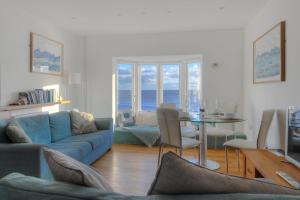 a living room with a blue couch and a table at Sea Fever in Lyme Regis