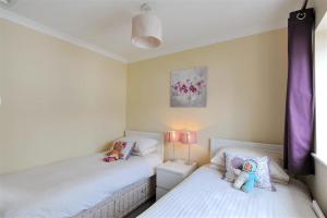 1 dormitorio con 2 camas con animales de peluche en The Old Bakehouse, en Lyme Regis