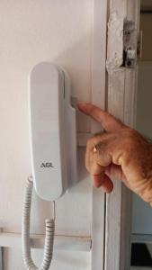 una mano apuntando a un teléfono en la pared en Apto-Comd Cj Eldorado - Alter Temporada en Manaus