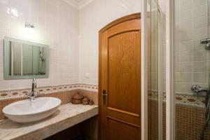 a bathroom with a sink and a shower at Golf- Villa mit fantastischer Aussicht, Pool, Jacuzzi, Sauna, Golf, Tennis... in Budens +17 photos