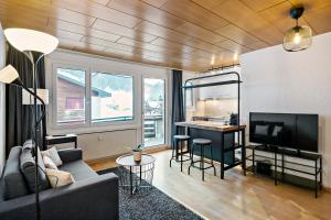 uma sala de estar com um sofá, uma mesa e uma cozinha em Apartment next to Titlis Station em Engelberg