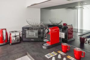 una cocina con un aparato rojo en una encimera en Appartement des Tours - Welkeys en La Rochelle