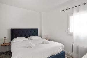 1 dormitorio con 1 cama blanca grande con almohadas blancas en Appartement des Tours - Welkeys en La Rochelle