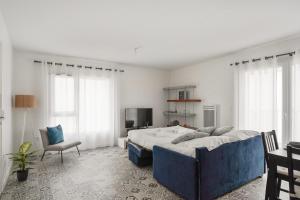- une chambre avec un grand lit et une chaise dans l'établissement Bel appartement avec balcon à 100m de la mer à La Rochelle - Welkeys, à La Rochelle