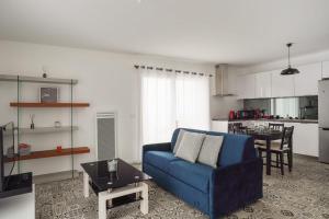 uma sala de estar com um sofá azul e uma cozinha em Appartement des Tours - Welkeys em La Rochelle